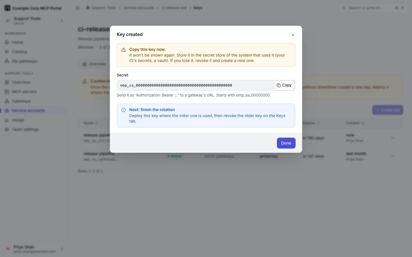 The "Key created" dialog for ci-release-bot, with the secret shown once (a fake value omp_sa_0000…) and "Next: finish the rotation".